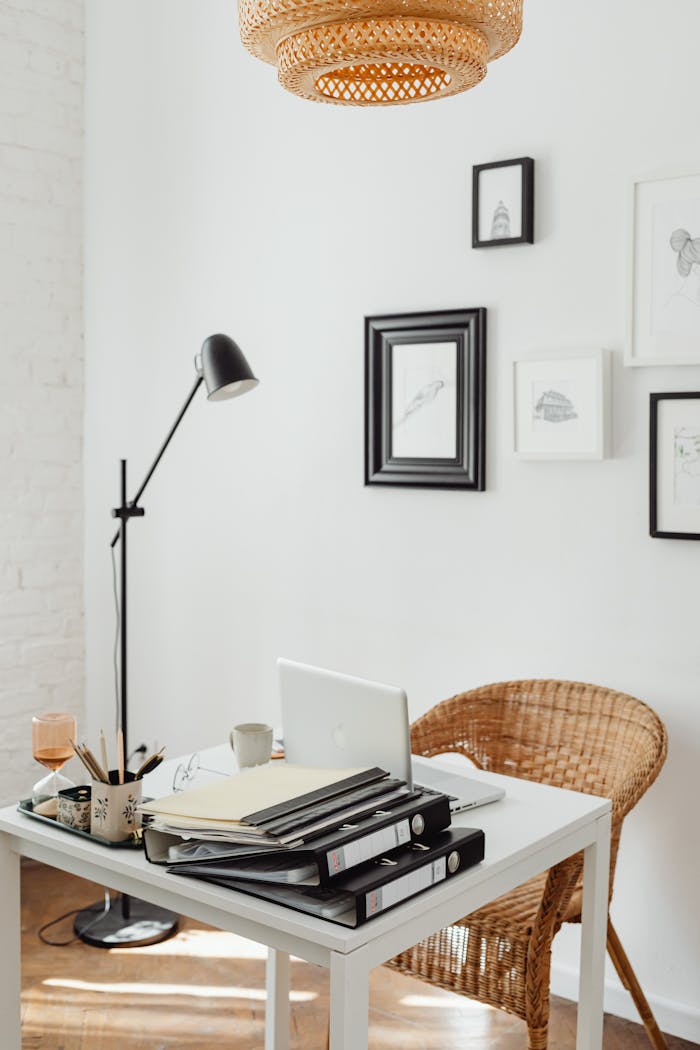 who-we-are Elegant home office with wicker chair, white desk, and decor accents for a serene working space.